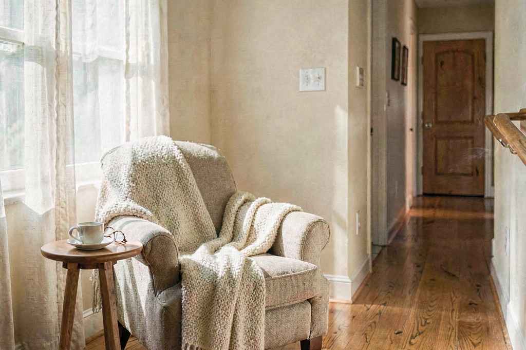 A warm, well-lit living room made safe for aging in place — grab rails along the hallway, clear pathways, and natural light